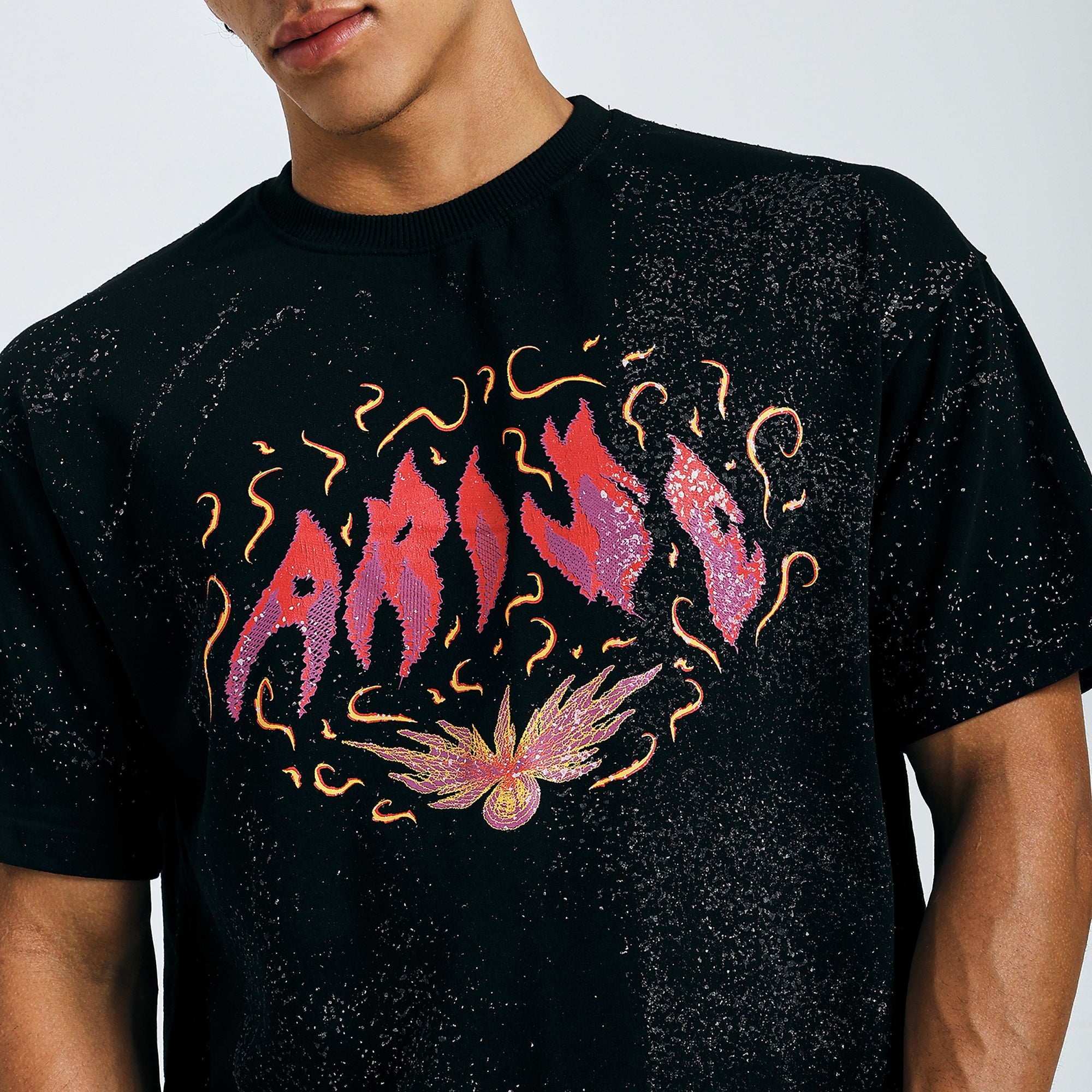 Close-up of black Arise graphic tee with fiery psychedelic design on chest