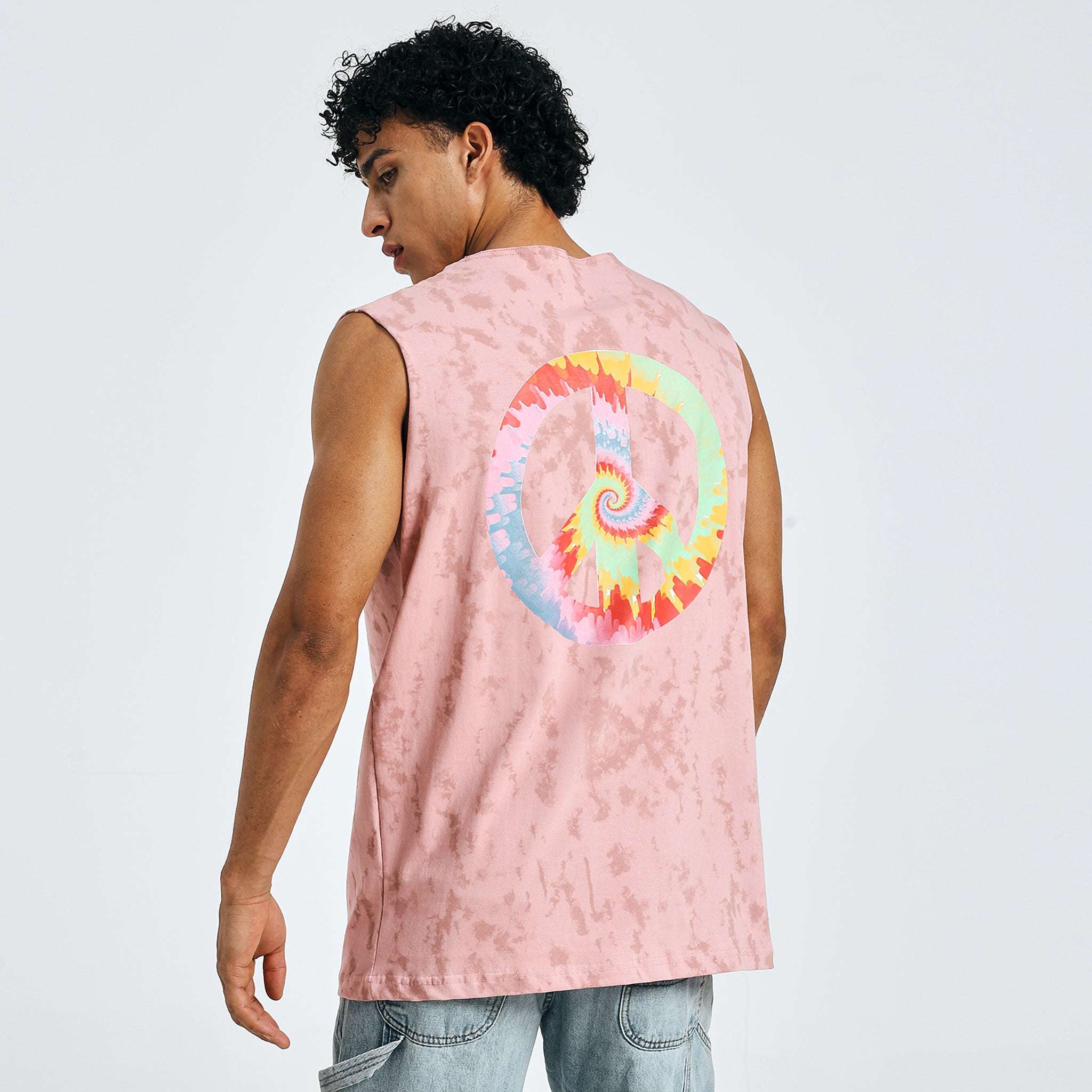 back view of pink “Trippy Hippie” sleeveless t-shirt showing colorful peace symbol and tie-dye art
