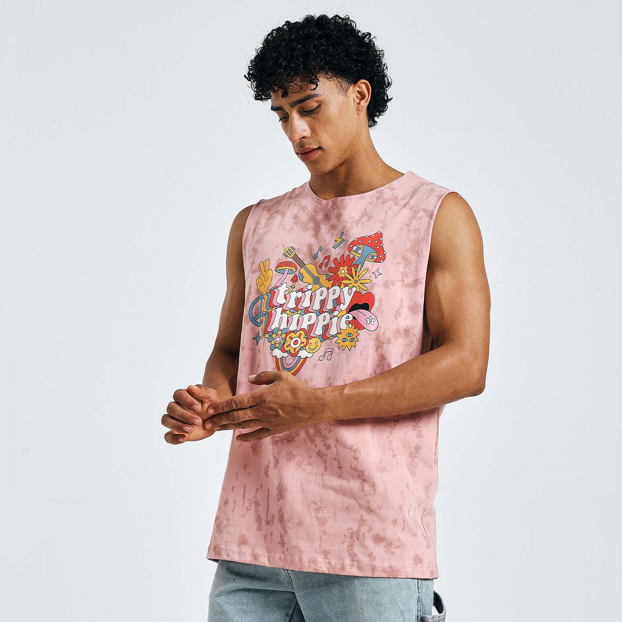 Side angle of model in pink sleeveless “Trippy Hippie” t-shirt