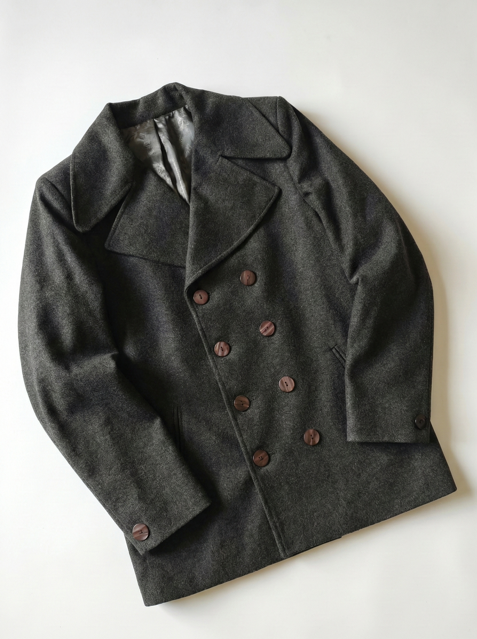 Dark gray peacoat with double-breasted buttons on a white background