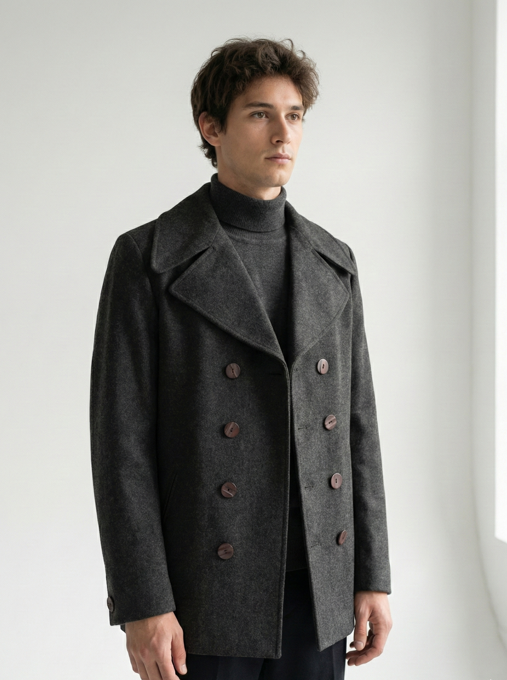 Man wearing a dark gray peacoat against a white background