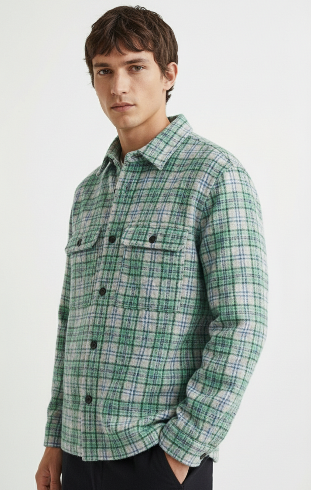 Man wearing a green plaid shirt against a white background