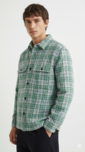 Man wearing a green plaid shirt against a white background