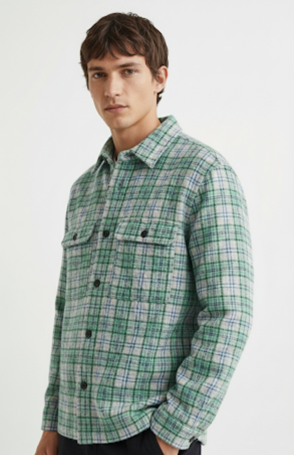 Man wearing a green plaid shirt against a white background