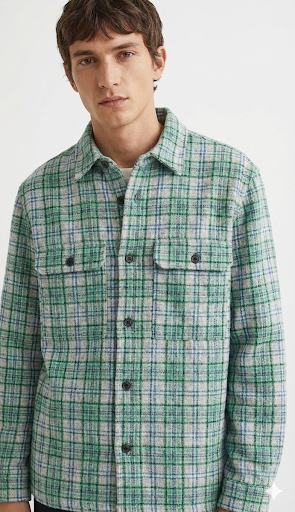 Man wearing a green plaid shirt against a white background