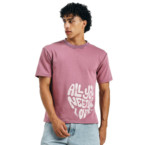 Man wearing a pink t-shirt with 'All You Need Is Love' text on a white background