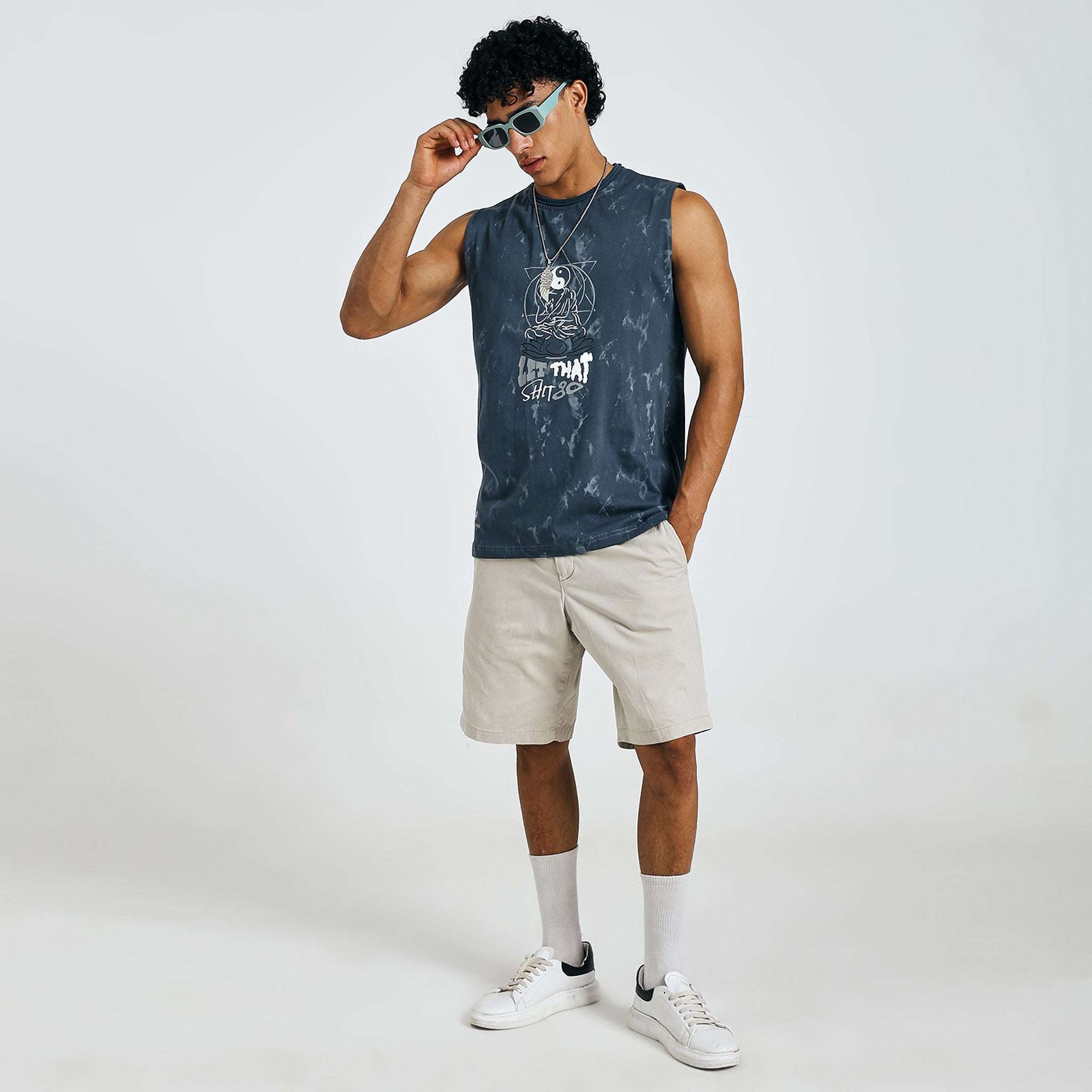 Dark blue tie-dye Yin-Yang tank with meditating figure print, "LET THAT SHIT GO" text, and raw edges on 240 GSM cotton sinker fabric.