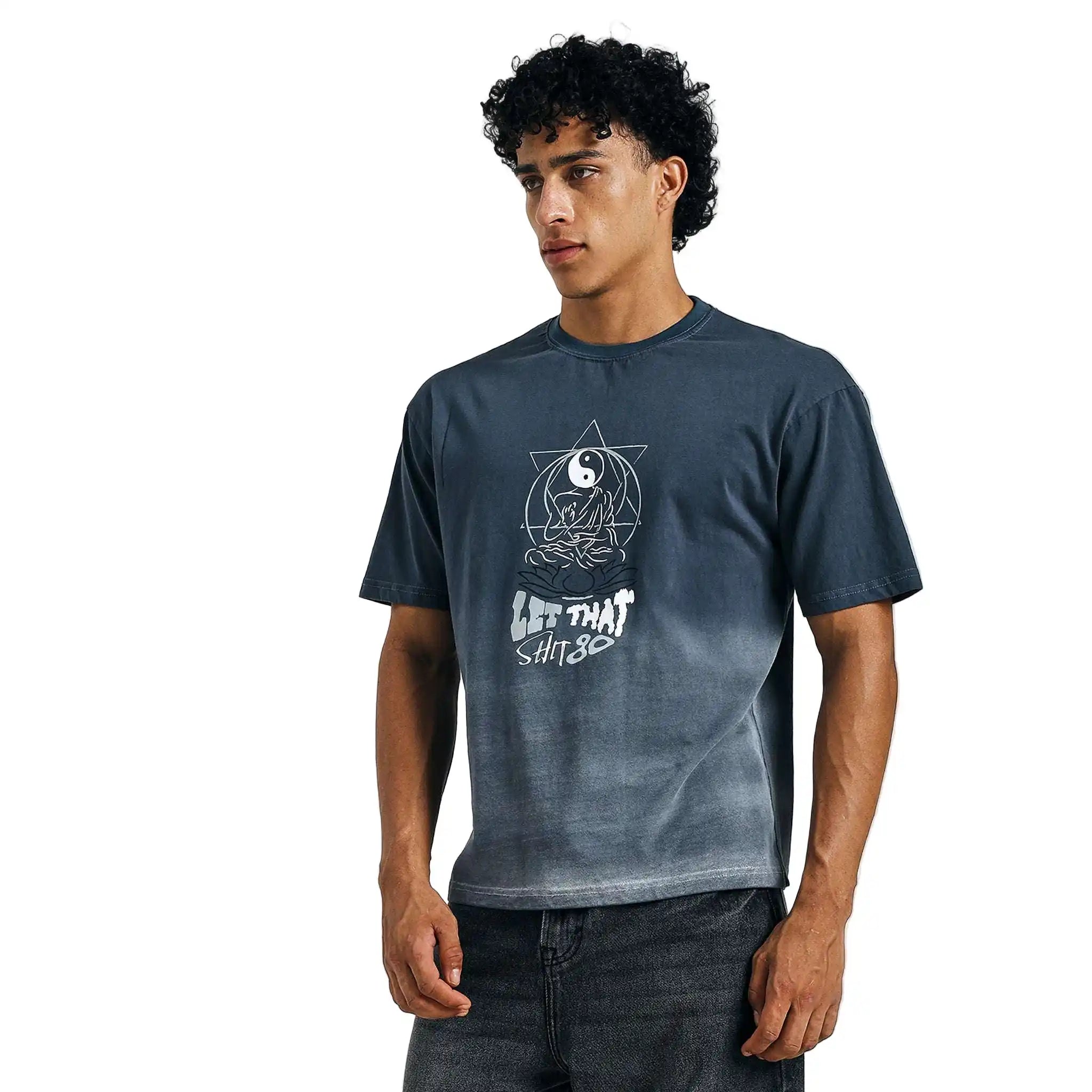 Man wearing a dark blue t-shirt with a graphic design on a light gray background