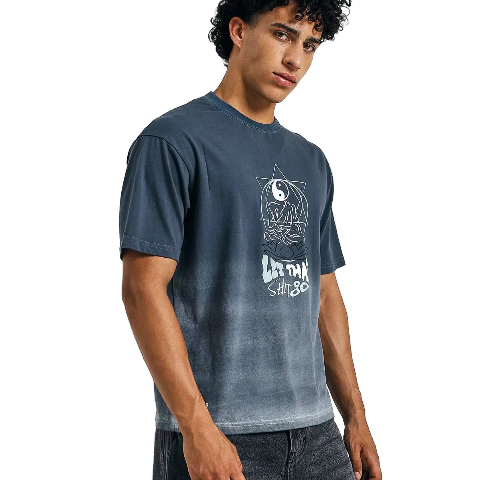 Man wearing a blue t-shirt with a graphic design on a light gray background