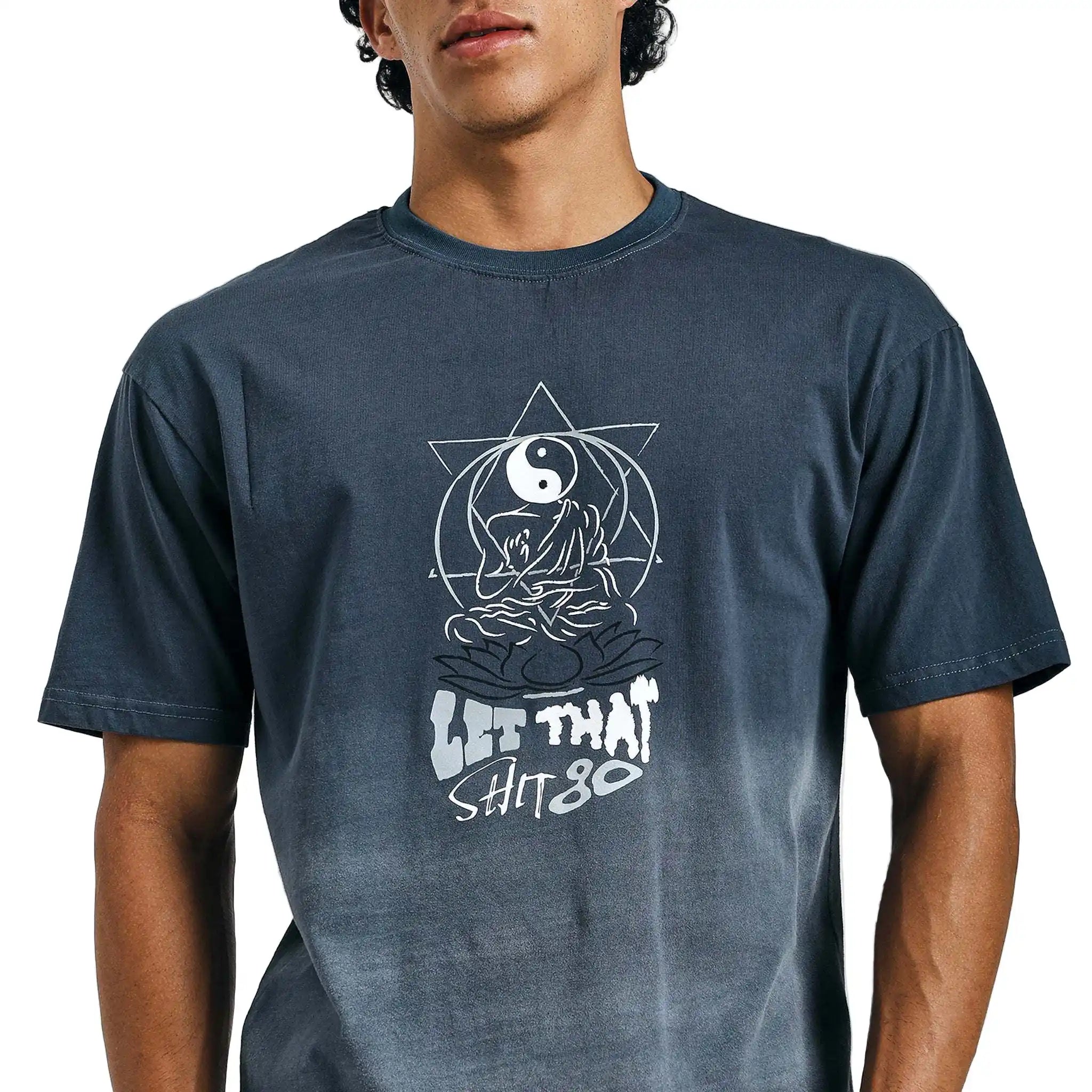 Person wearing a navy blue t-shirt with a graphic design and text on a plain background