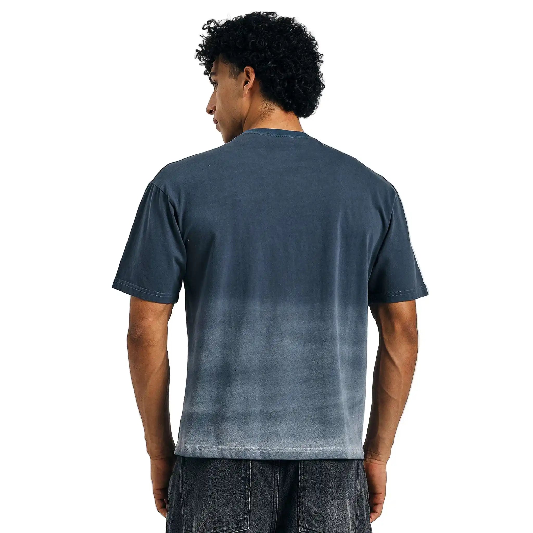 Person wearing a gray t-shirt with a gradient effect on a plain background