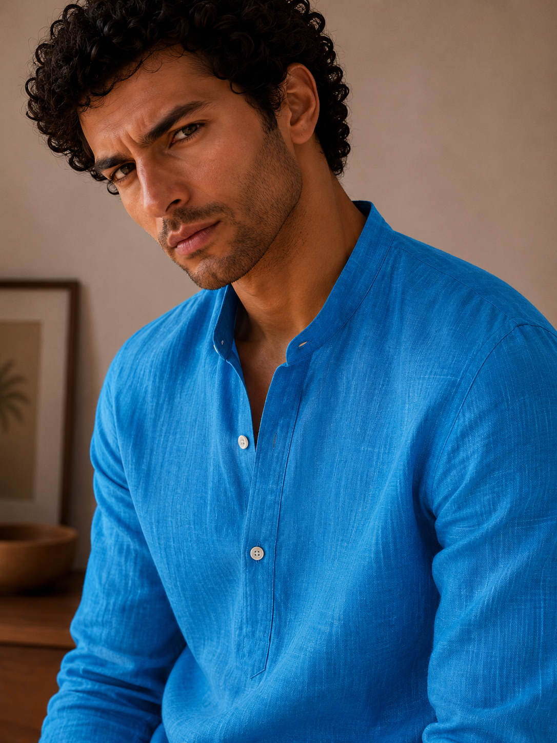 Man wearing a blue shirt against a neutral background