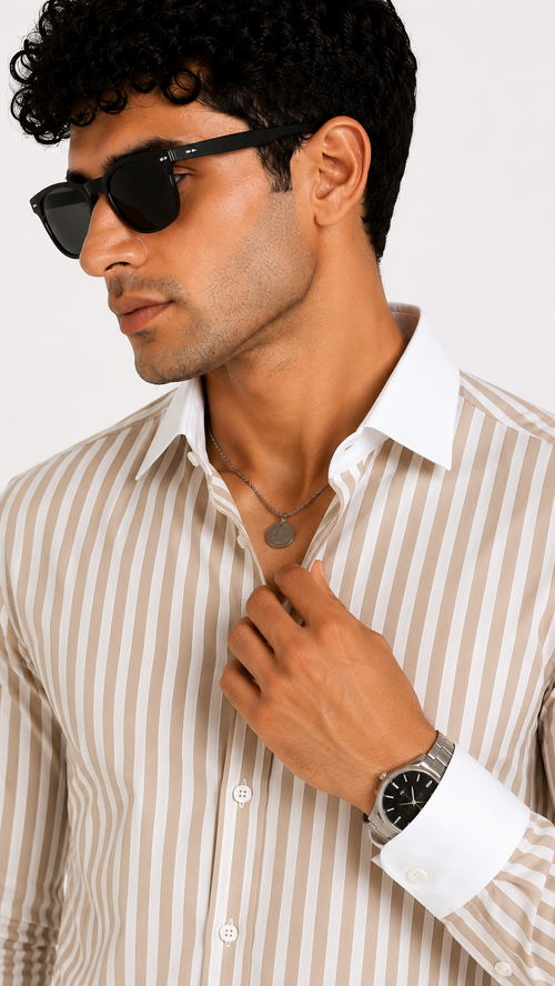 Man wearing a striped shirt, sunglasses, and a watch against a white background