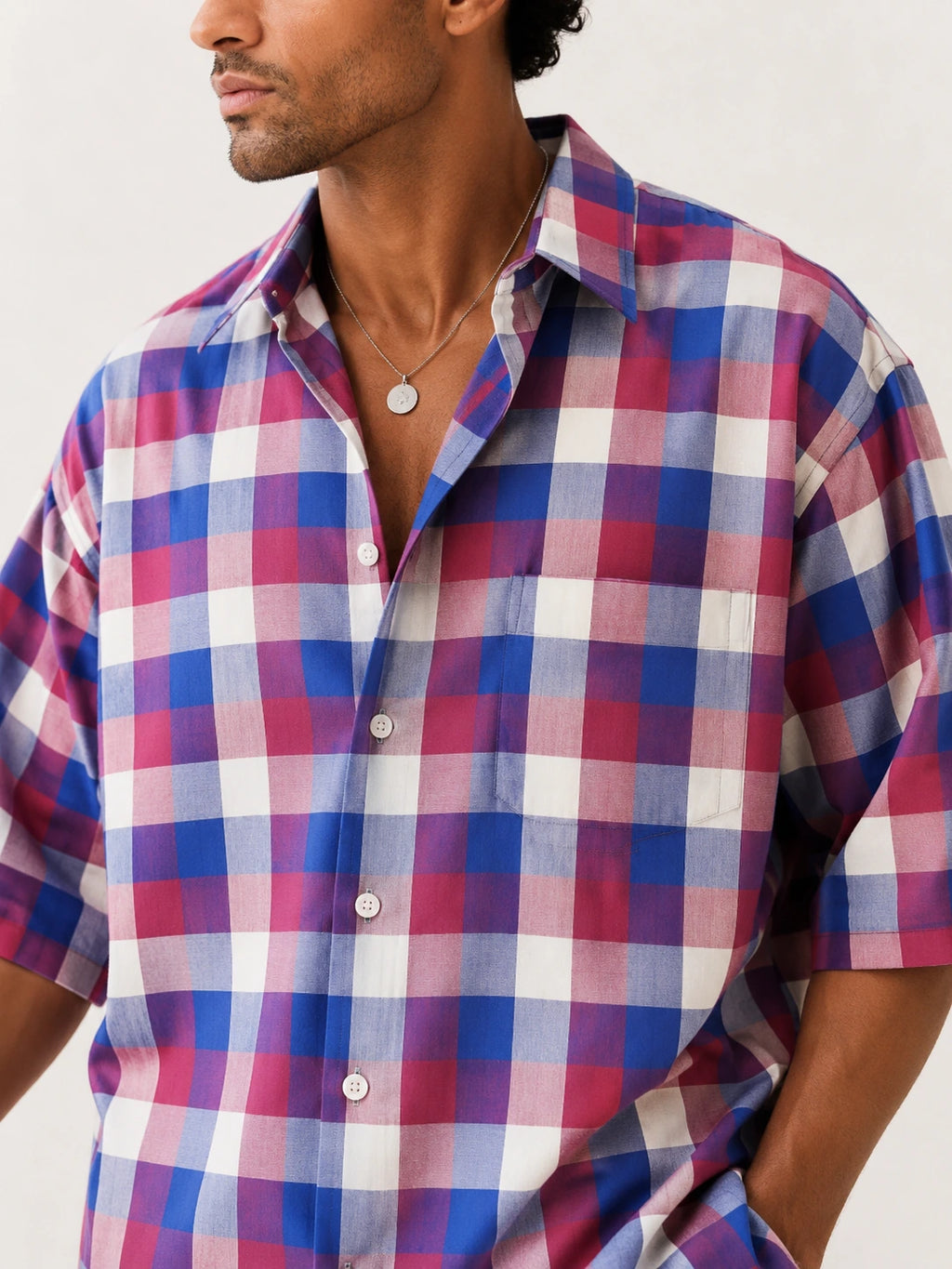 Man wearing a plaid shirt with a neutral background