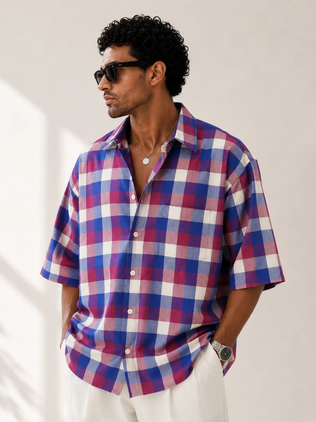 Man wearing a plaid shirt with a neutral background