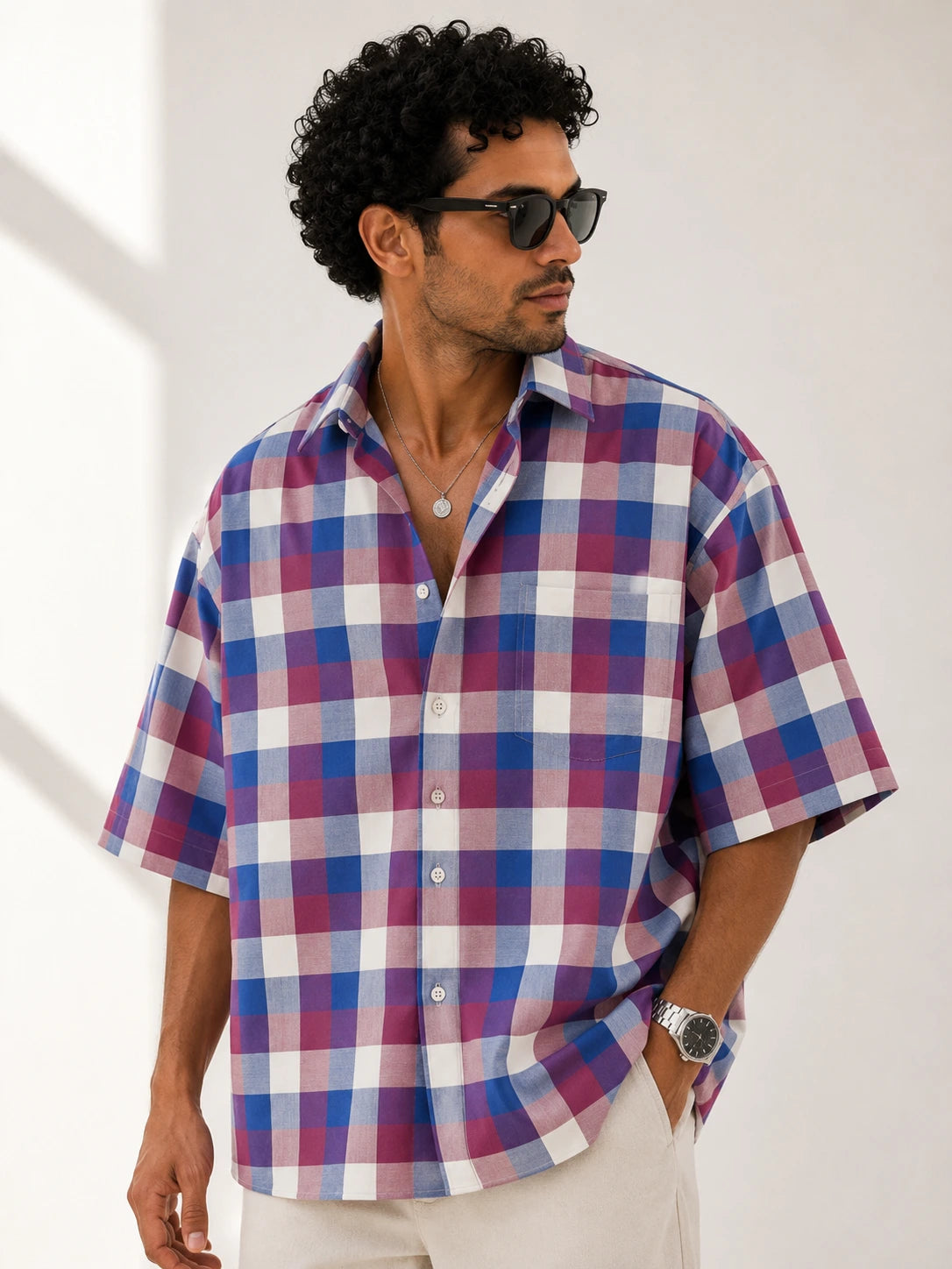 Man wearing a plaid shirt with a neutral background