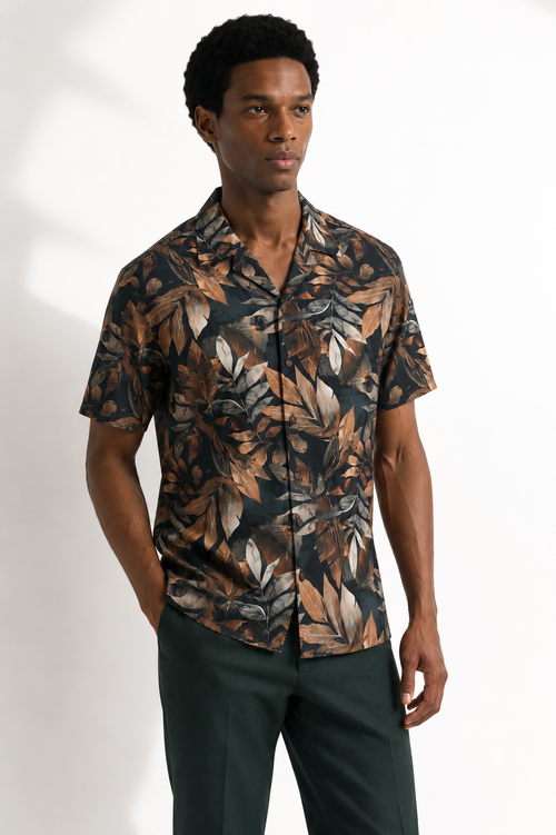 Man wearing a patterned shirt with a neutral background