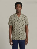 Man wearing a patterned shirt with a neutral background
