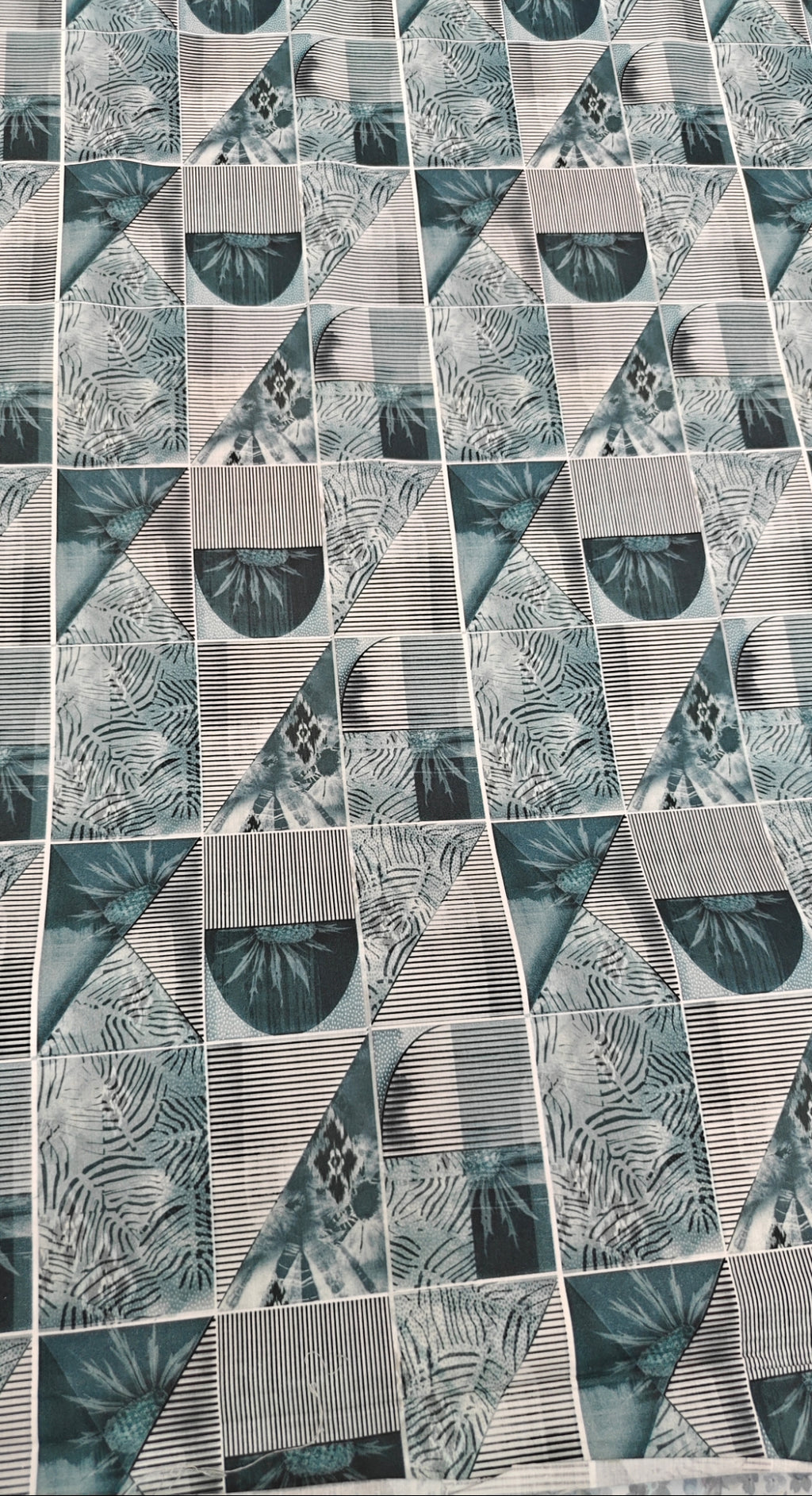 Patterned tile with geometric design in shades of green and gray