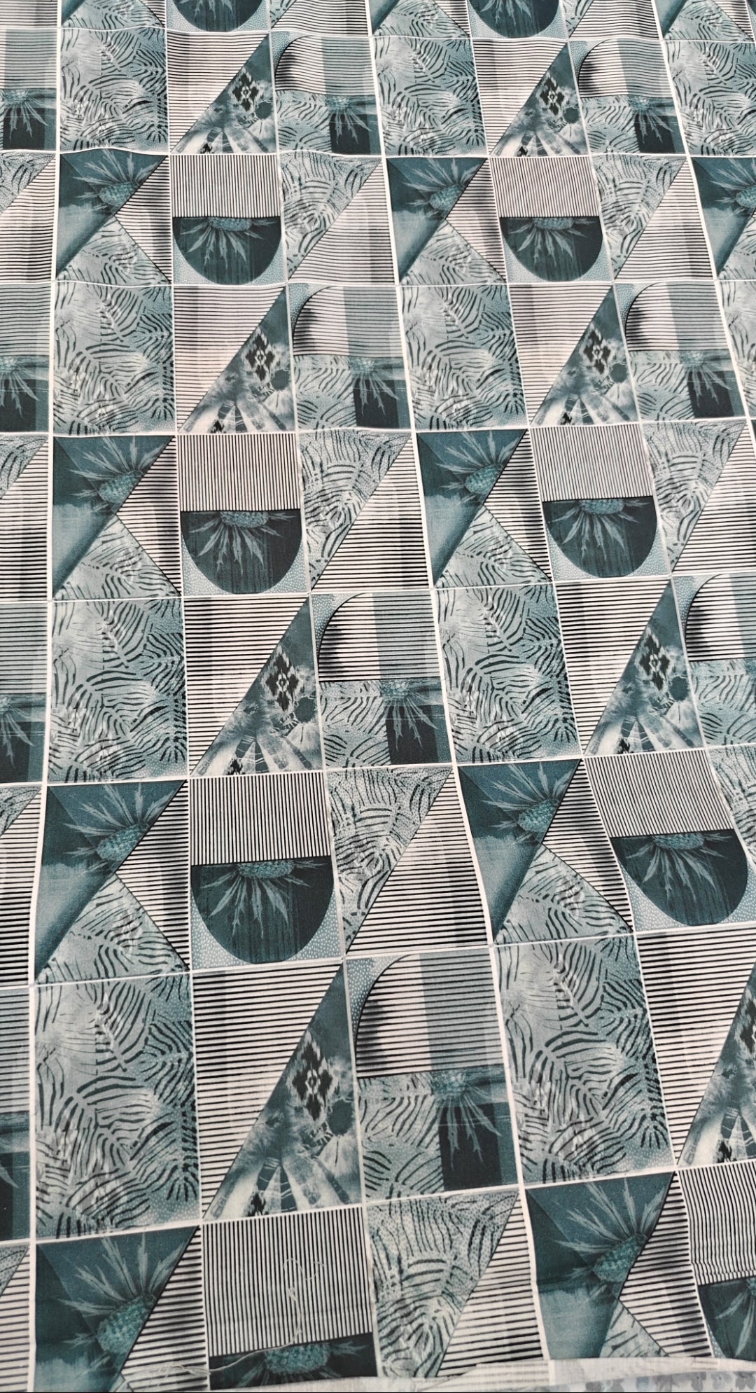 Patterned tile with geometric design in shades of green and gray