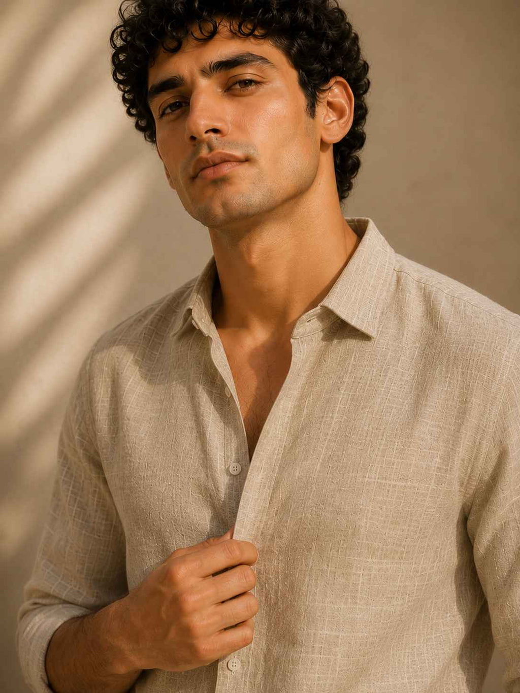 Man wearing a beige linen shirt against a neutral background