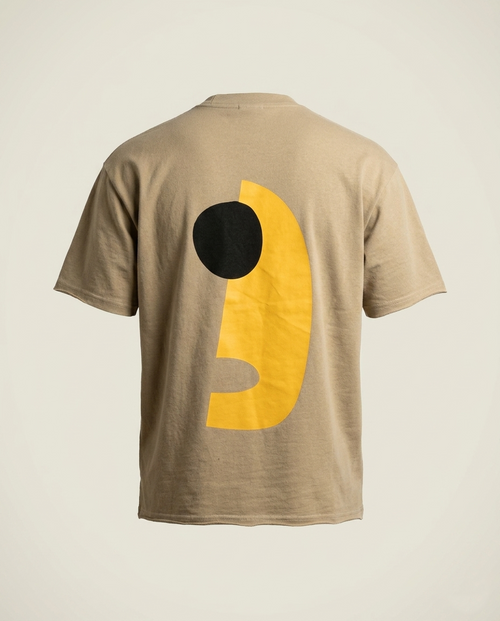 Beige t-shirt with a black and yellow graphic on the back against a beige background