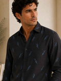Man wearing a dark patterned shirt indoors