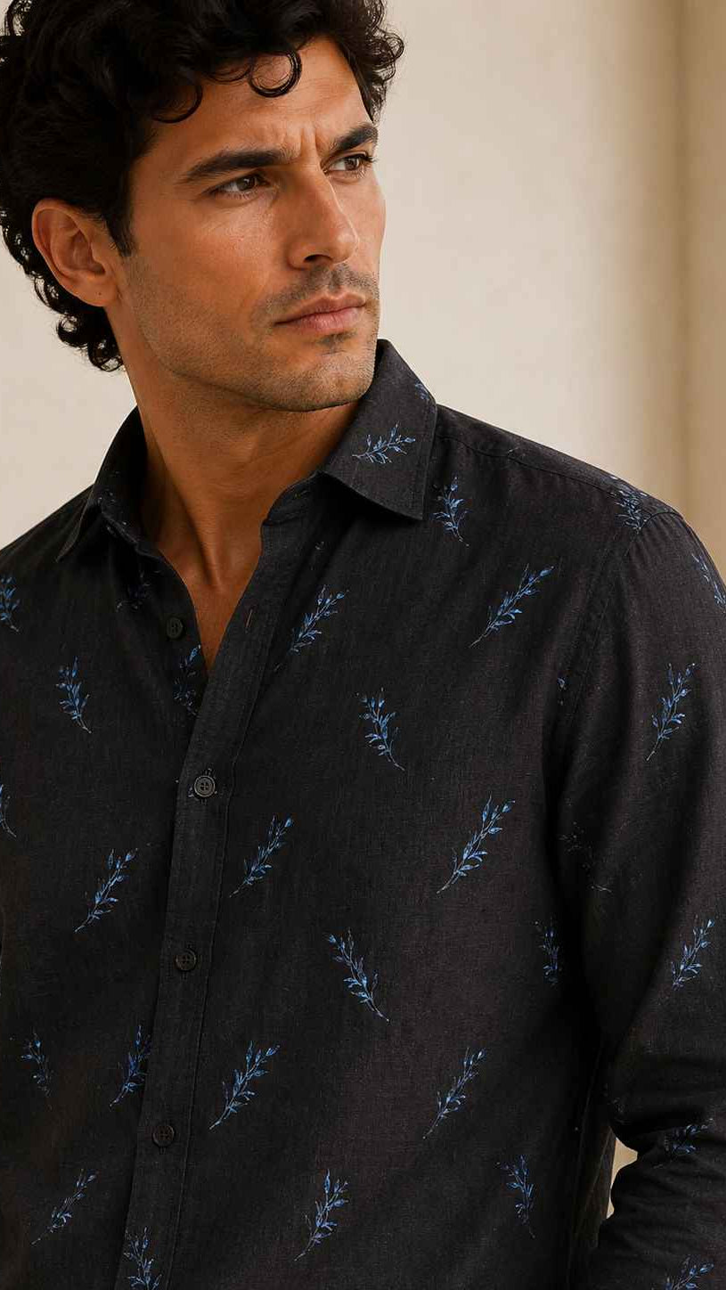 Man wearing a dark patterned shirt indoors