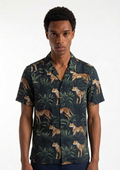 Man wearing a shirt with a leopard and jungle leaf pattern on a white background
