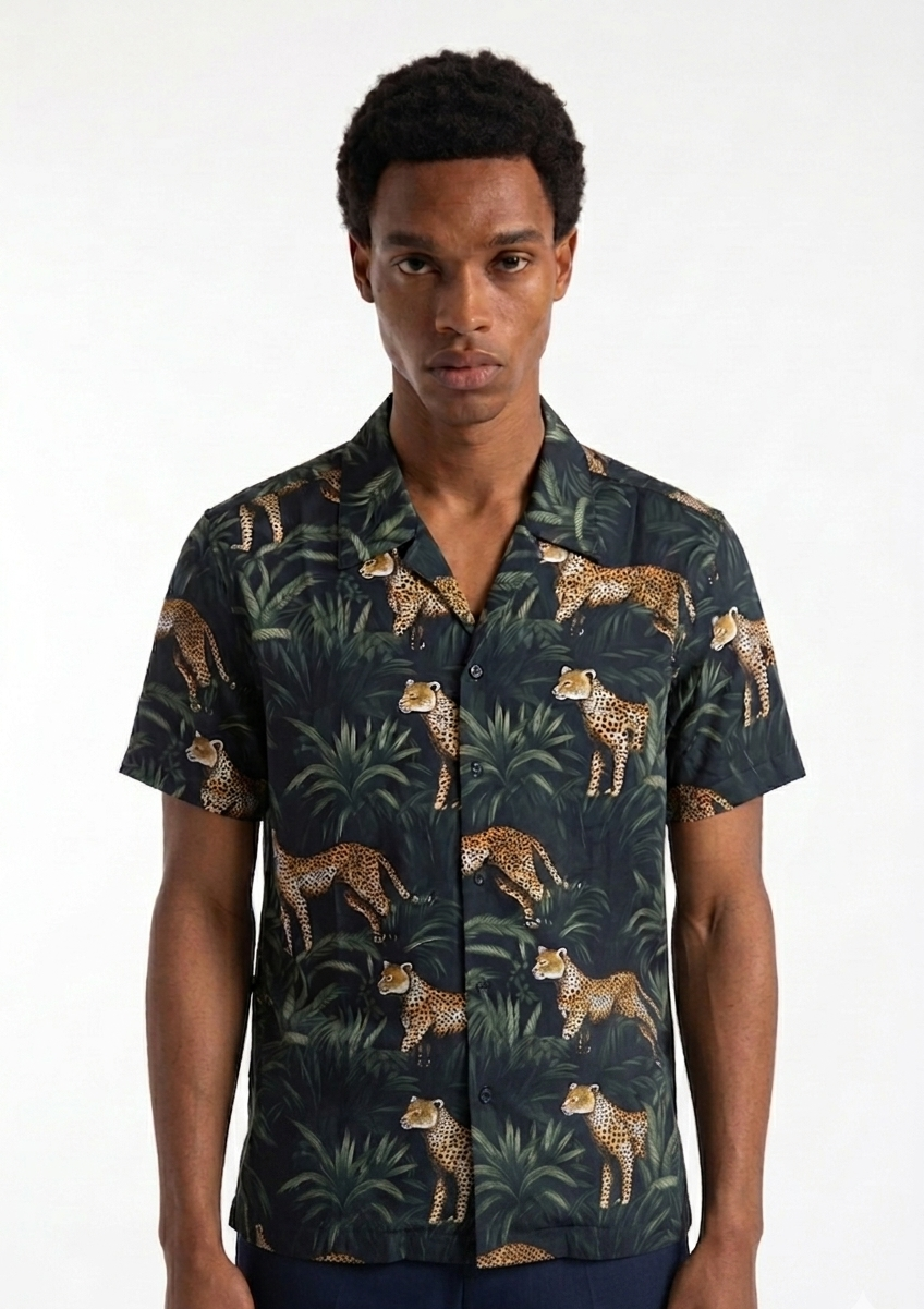 Man wearing a shirt with a leopard and jungle leaf pattern on a white background