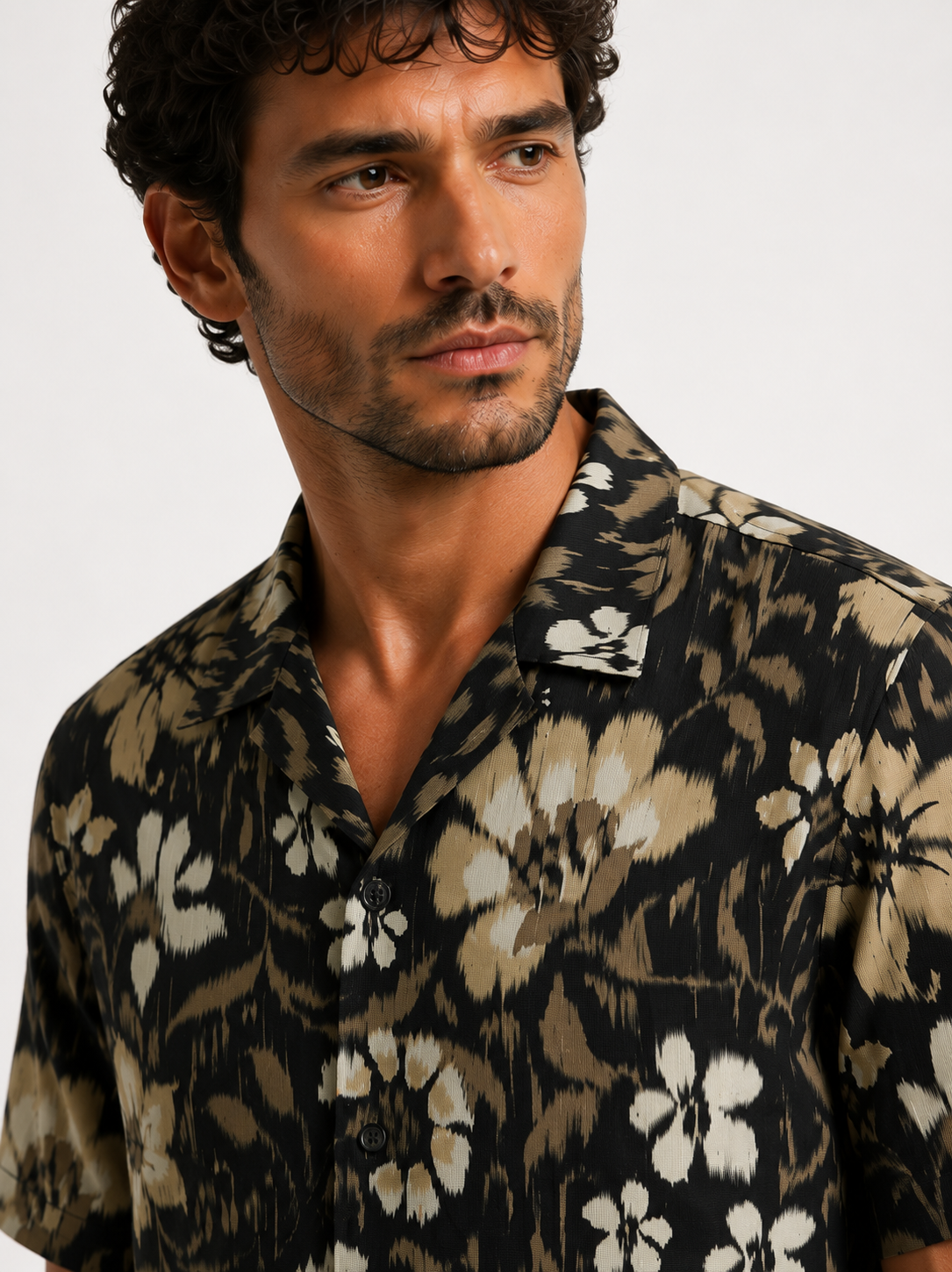 Man wearing a patterned shirt against a plain background