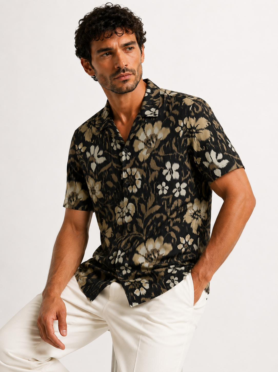 Man wearing a black floral patterned shirt against a white background