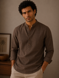 Man wearing a brown long-sleeve shirt against a neutral background