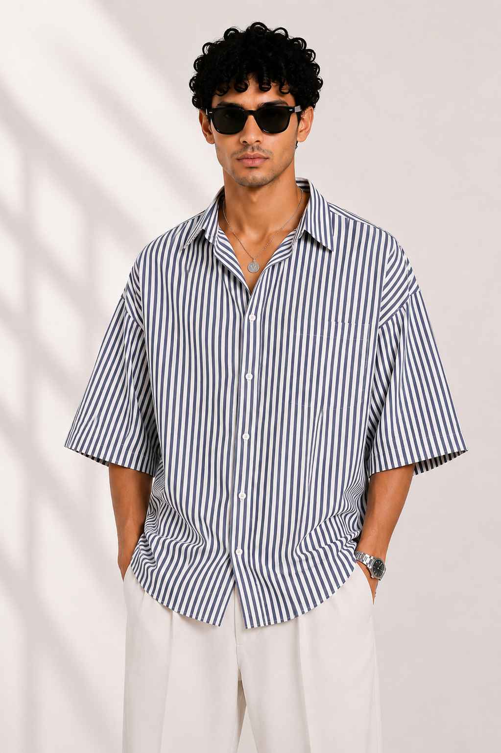 Man wearing a black and white striped shirt with a plain background