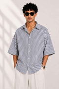 Man wearing a black and white striped shirt with a plain background