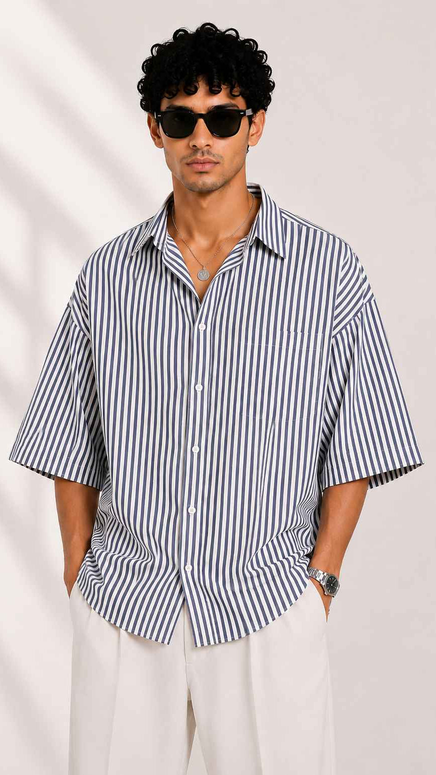 Man wearing a black and white striped shirt with a plain background