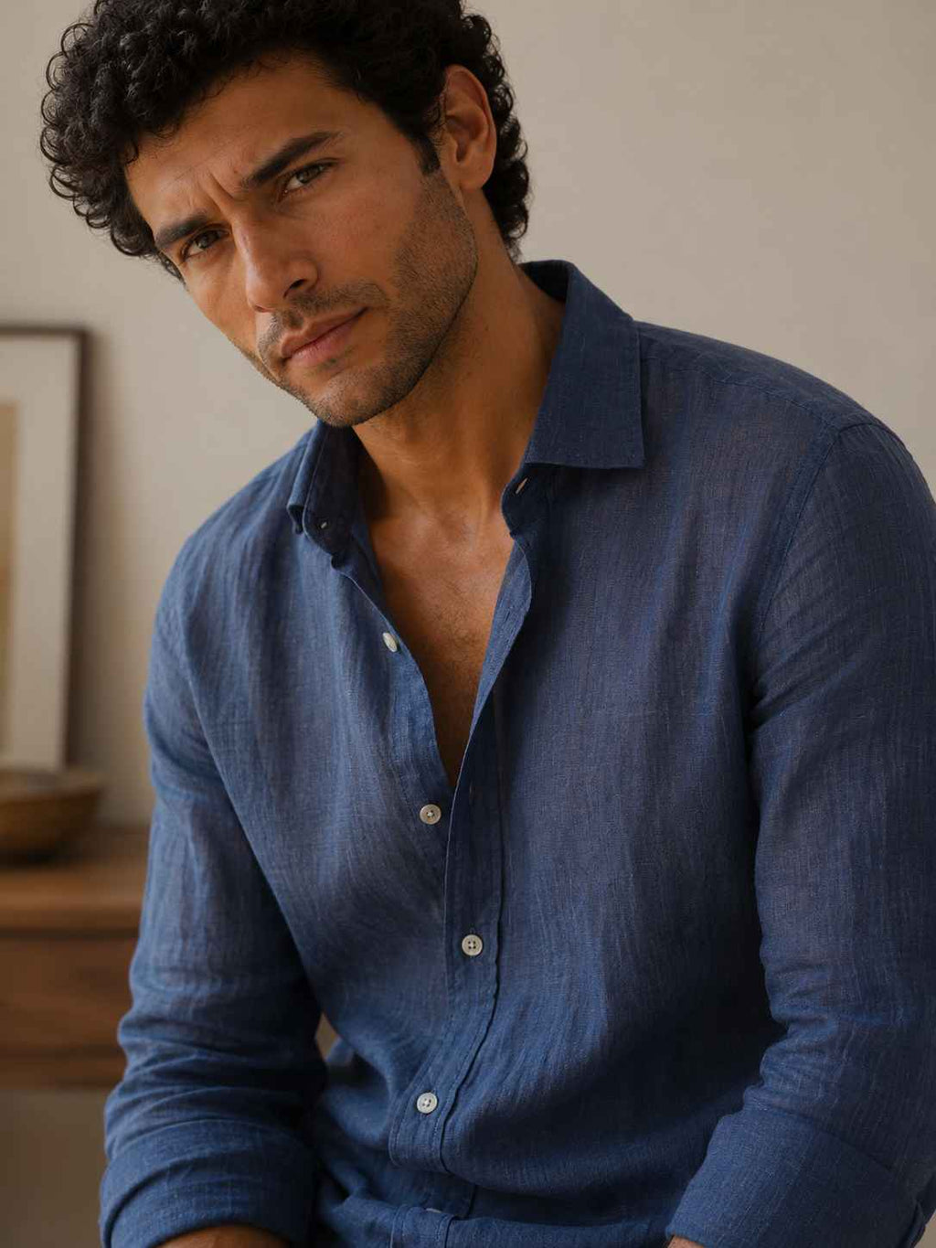 Man wearing a blue shirt with a neutral background