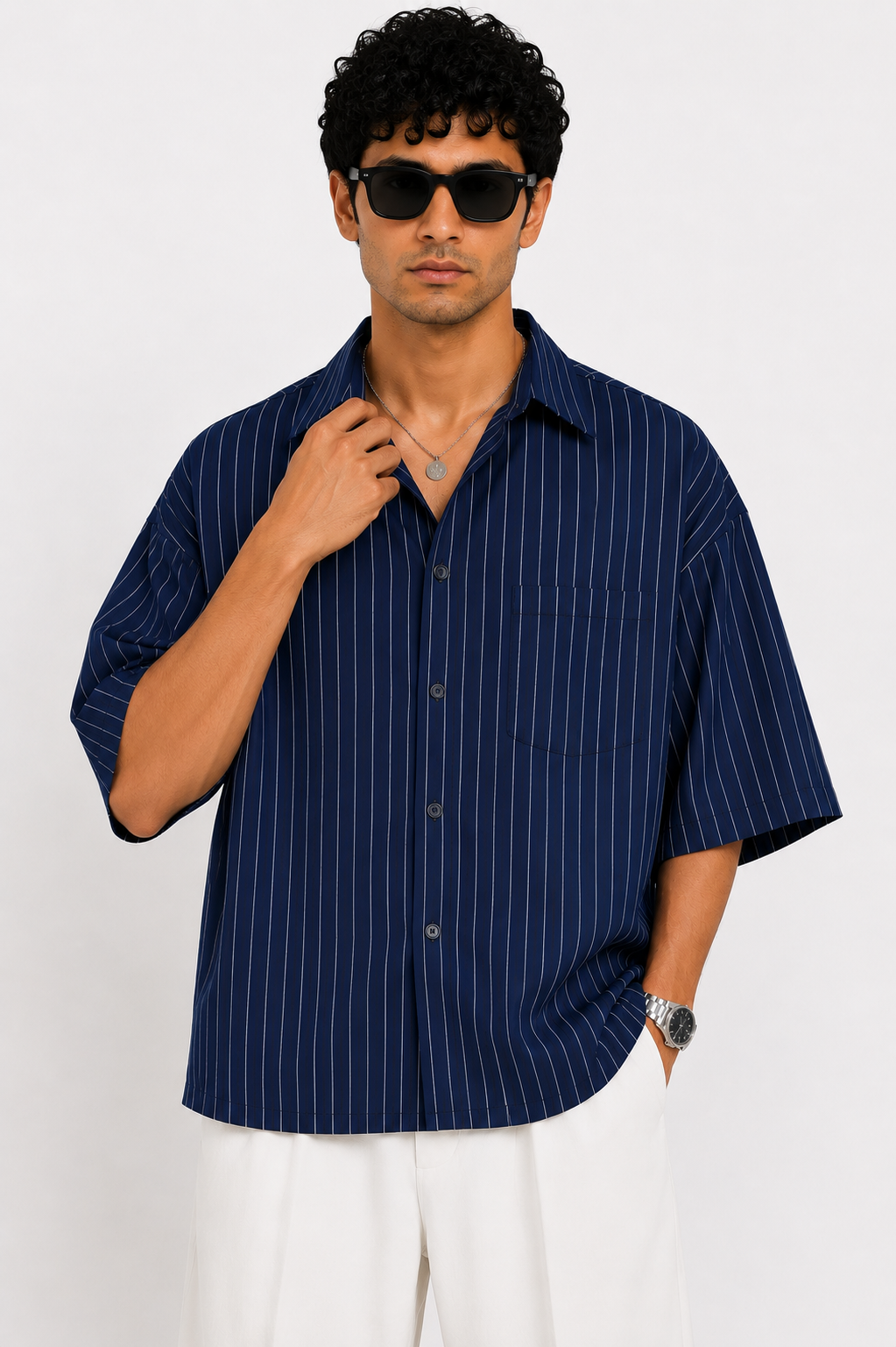Man wearing a navy striped shirt and sunglasses on a white background