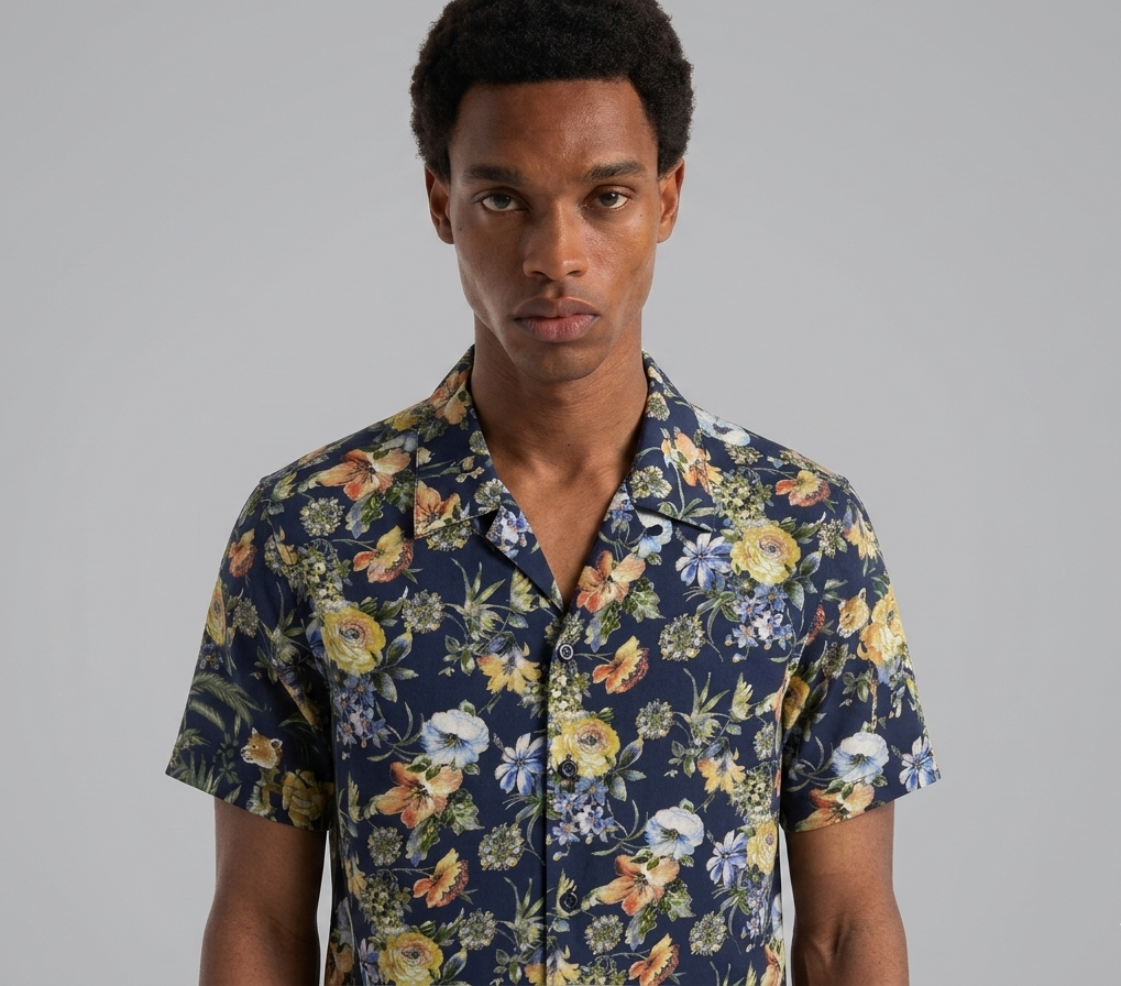 Man wearing a floral short-sleeve shirt against a gray background