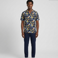 Man wearing a floral shirt and navy pants on a white background