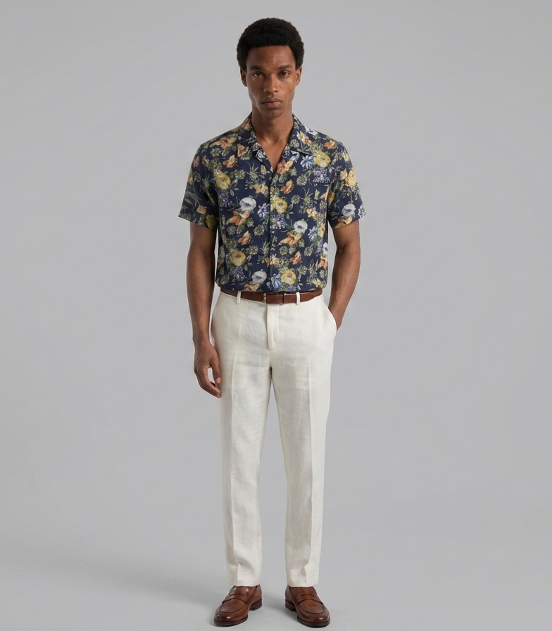 Man wearing a floral shirt and white pants on a gray background