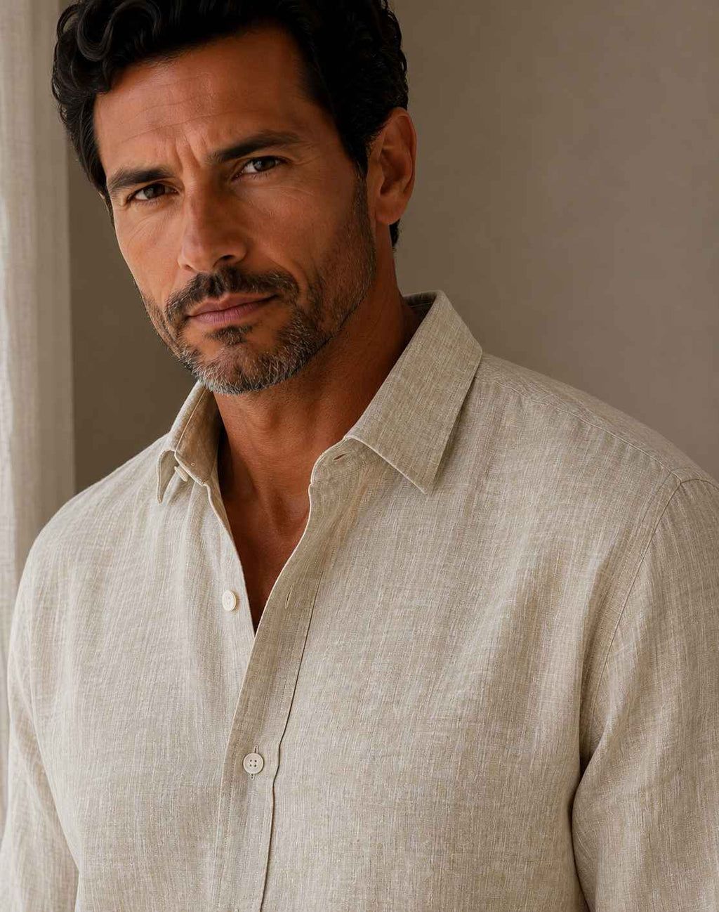 Man wearing a beige linen shirt against a neutral background