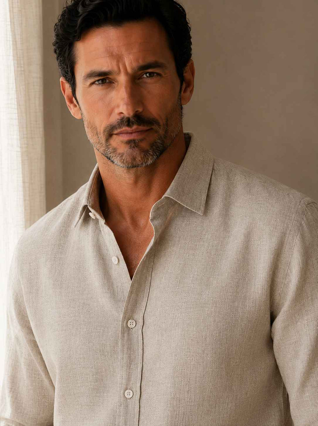Man wearing a beige linen shirt against a neutral background