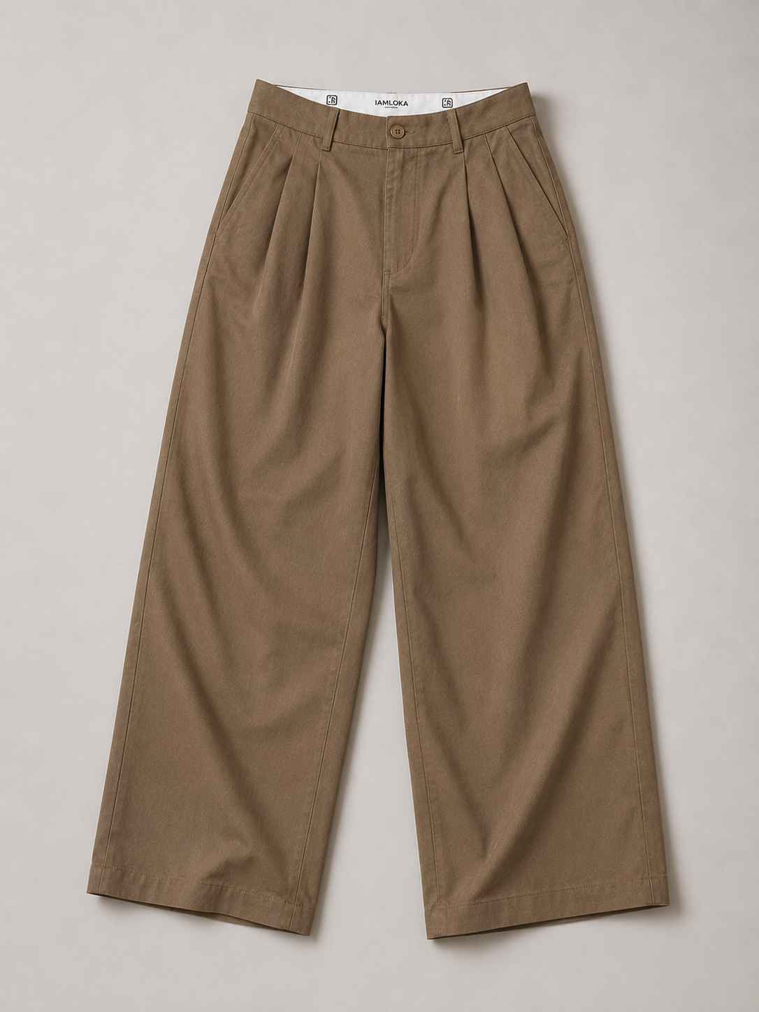 A pair of wide-leg cropped trousers in a warm taupe-brown color, laid flat on a neutral light gray background. The pants feature a button closure, belt loops, and a front pleat detail on the right leg.