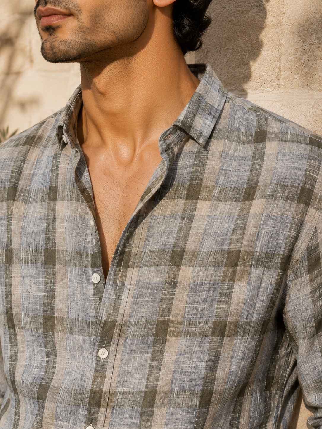 Man wearing a plaid shirt with a neutral background