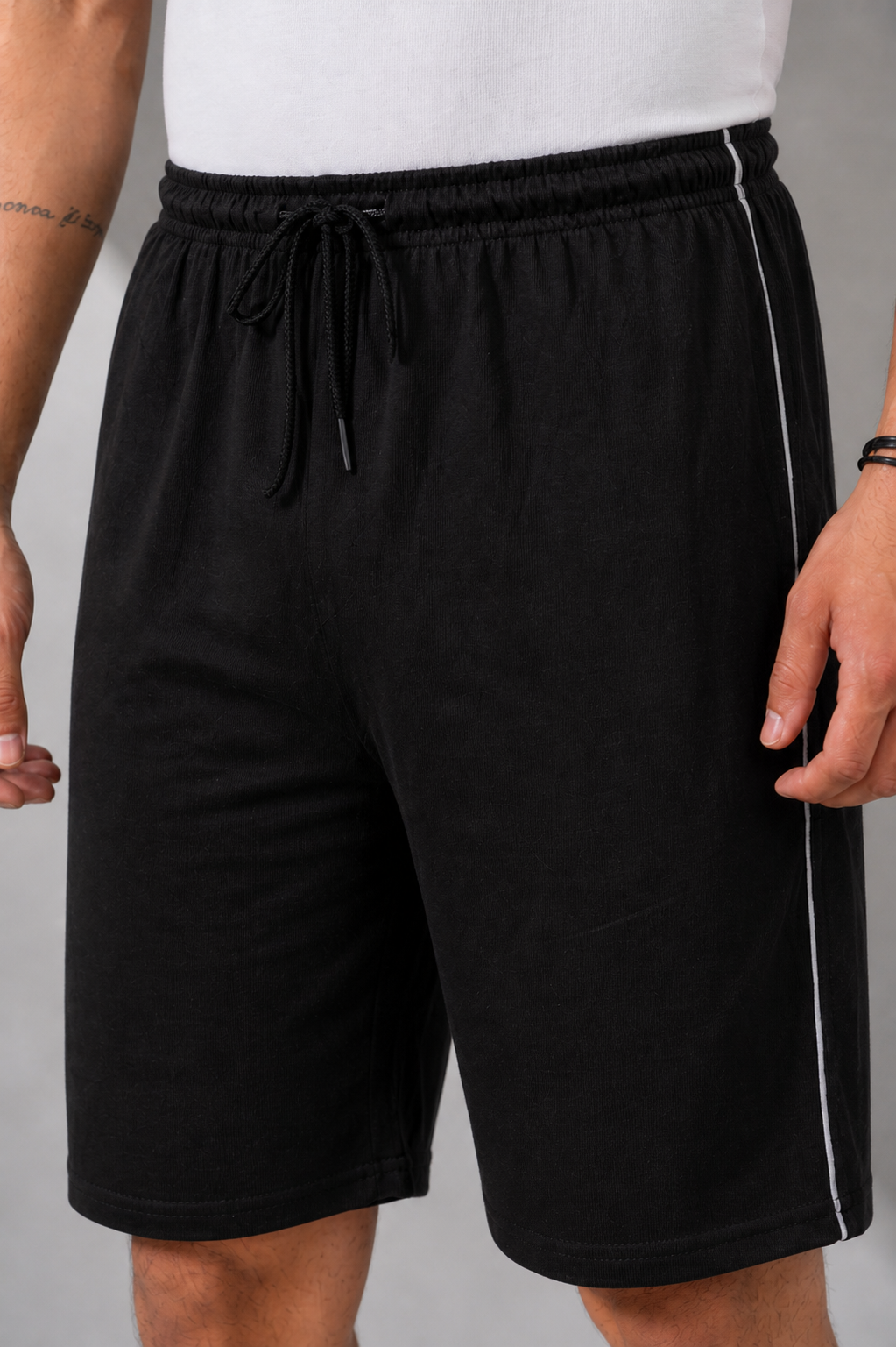 Black shorts with a white stripe on a gray background