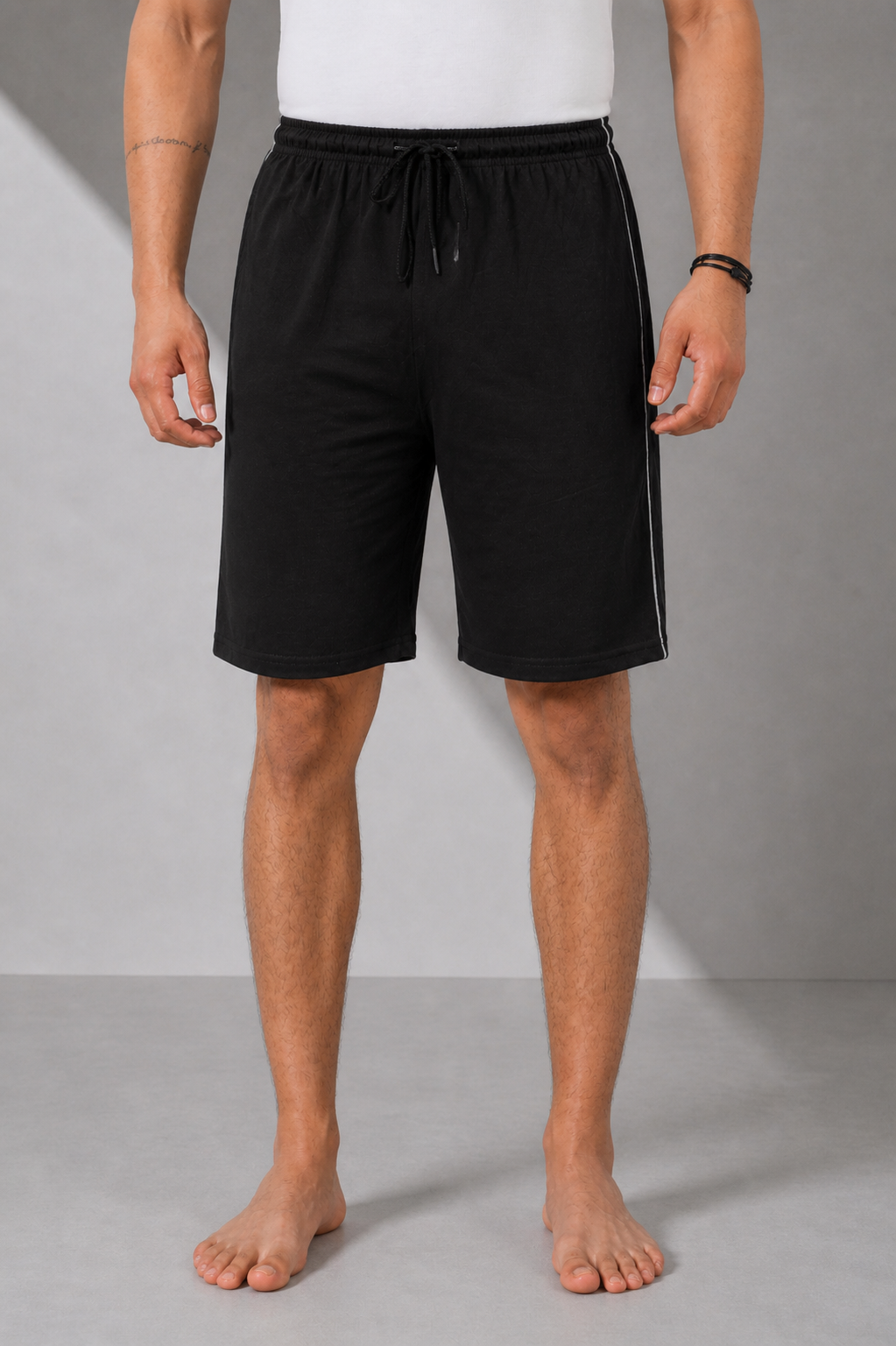 Person wearing black shorts on a gray background