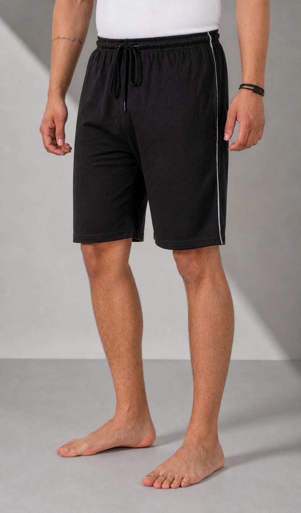 Person wearing black shorts on a gray background