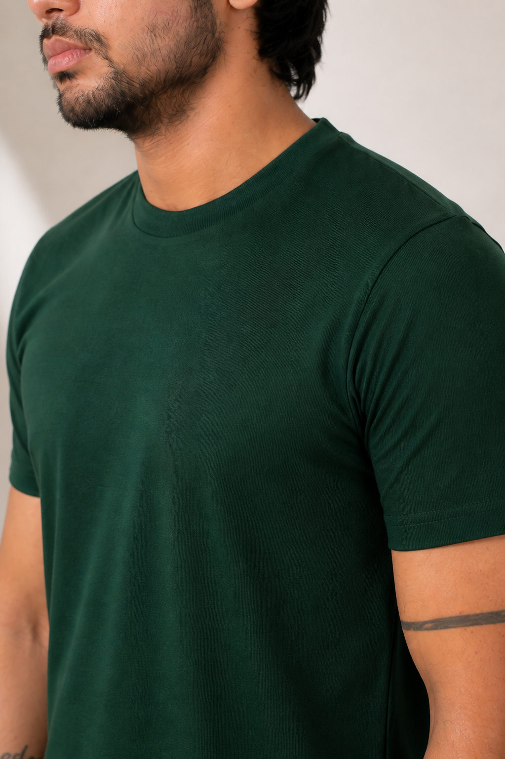 Man wearing a dark green t-shirt against a neutral background