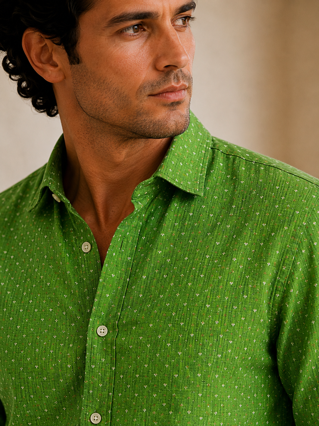 Man wearing a green patterned shirt against a neutral background